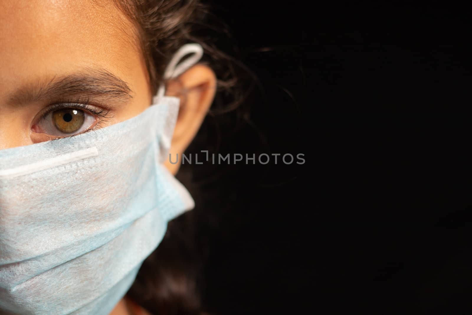 young girl child with medical mask wearing, protection against covid 19 or coronavirus pandemic on black background with copy space. by lakshmiprasad.maski@gmai.com