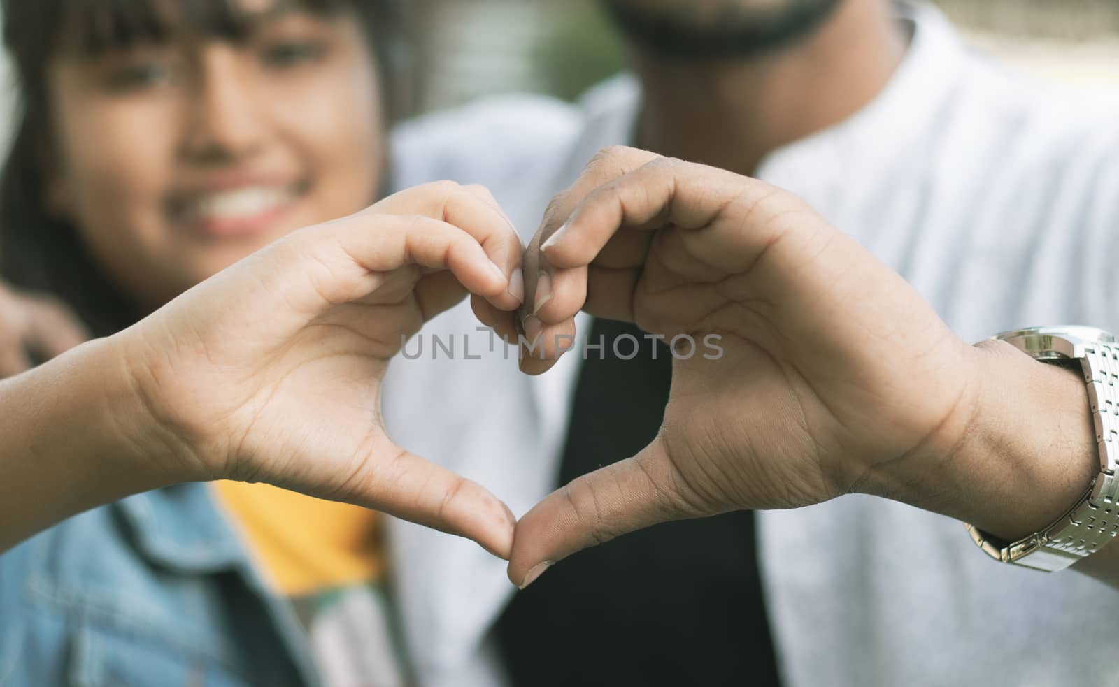 Couple in love showing heart with their hands - Concept of happy couple relationship and togetherness.