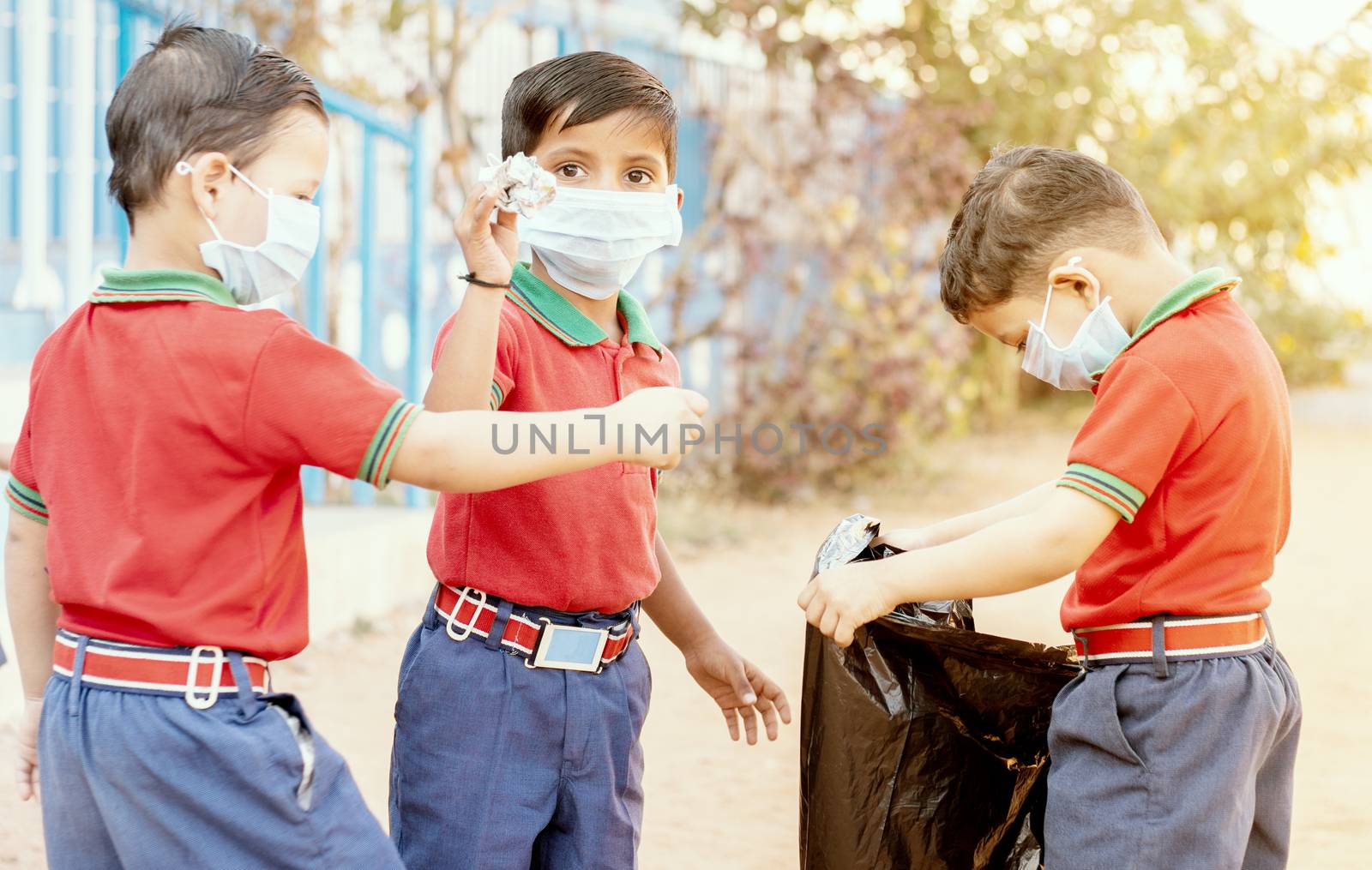 Group of children volunteers picking up, cleaning trash at school - concept of school kids or classmates collecting trash, charity environment