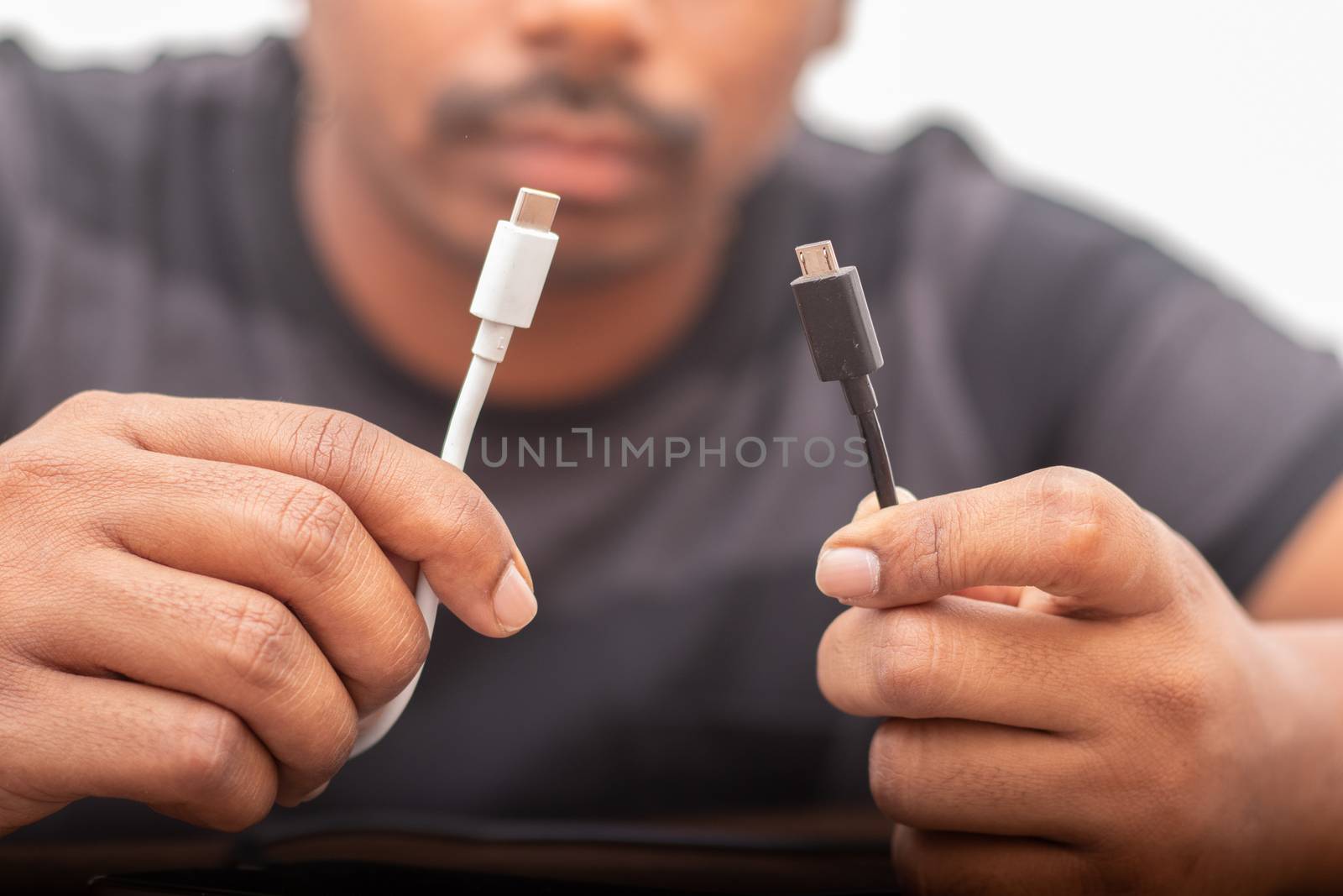 Selective focus on hands holding micro usb and USB type C ports concepts showing of confusion on charging ports