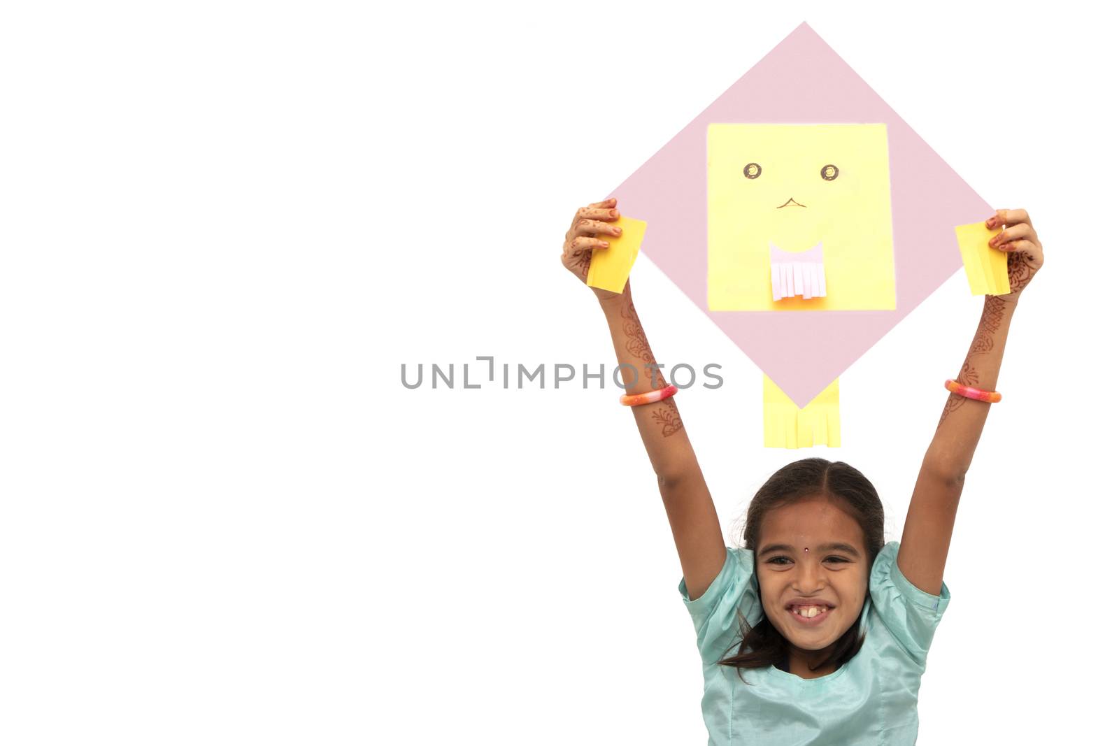 Young Indian village traditional girl with excitement holding kite over isolated background - concept of kids playing kites during sankranti festival. by lakshmiprasad.maski@gmai.com