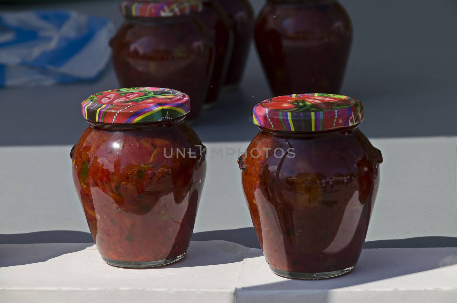 Glass jar with traditional home-made classic spicy salsa tomato, chili, garlic and pepper  on fire, Sofia, Bulgaria