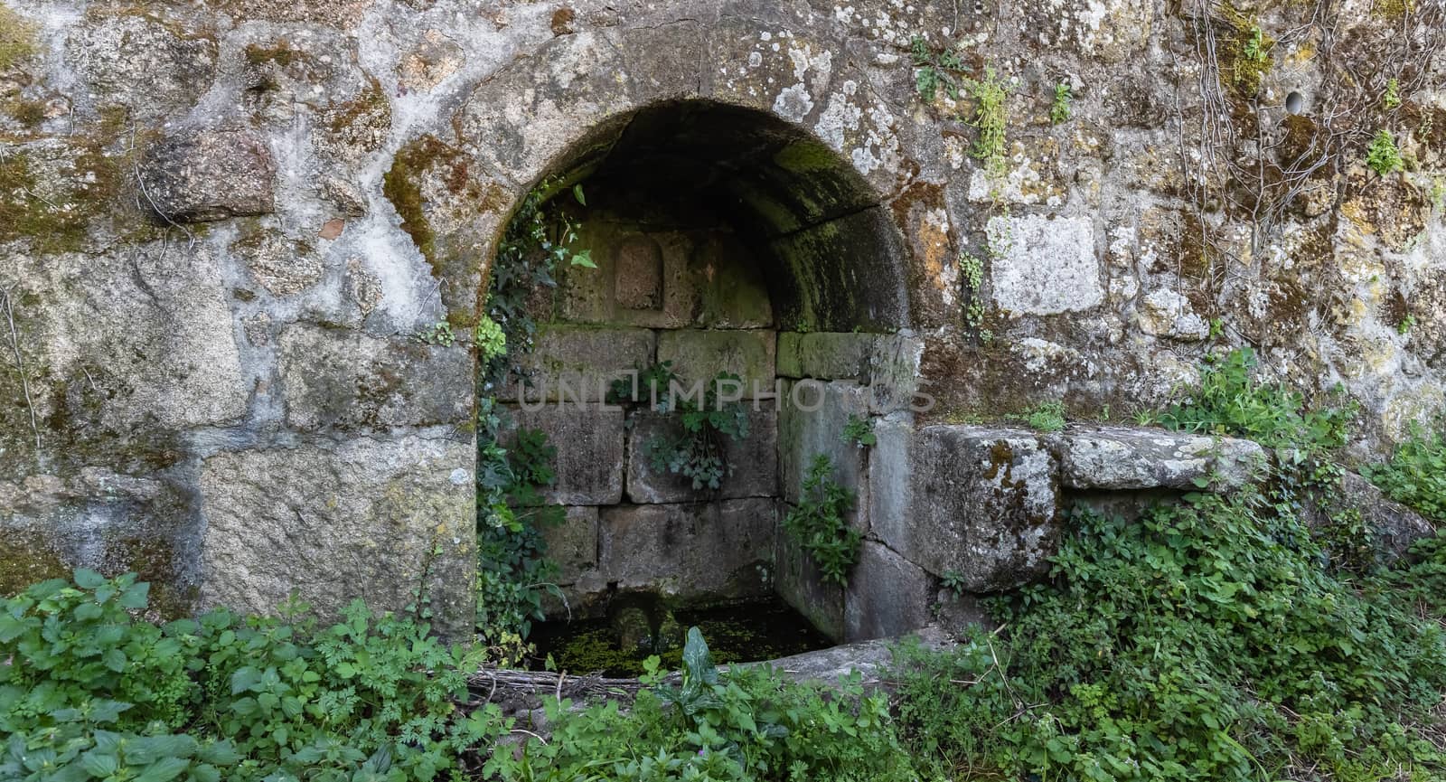 old stone water source in portugal - ancient well in the countryside