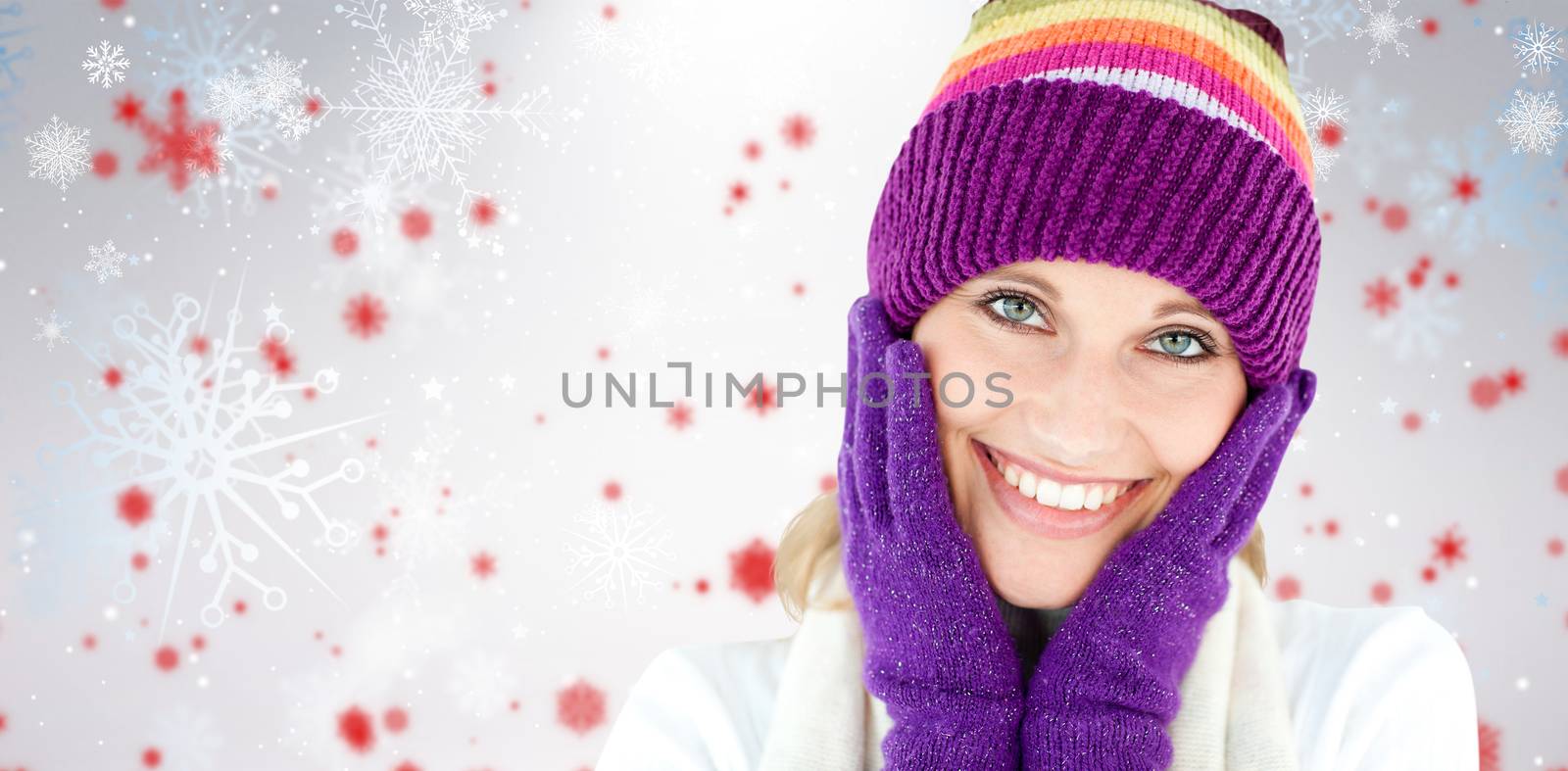 Radiant young woman with cap and gloves in the winter against snowflake pattern