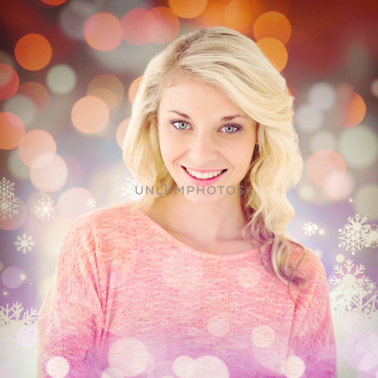 Pretty blonde smiling with arms crossed against snowflake pattern