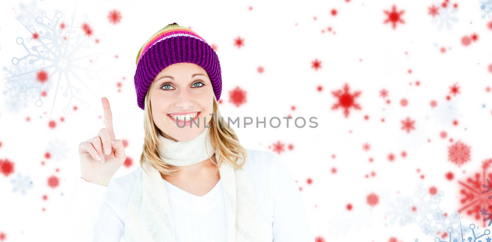 Composite image of joyful woman with a colorful hat pointing upwards by Wavebreakmedia