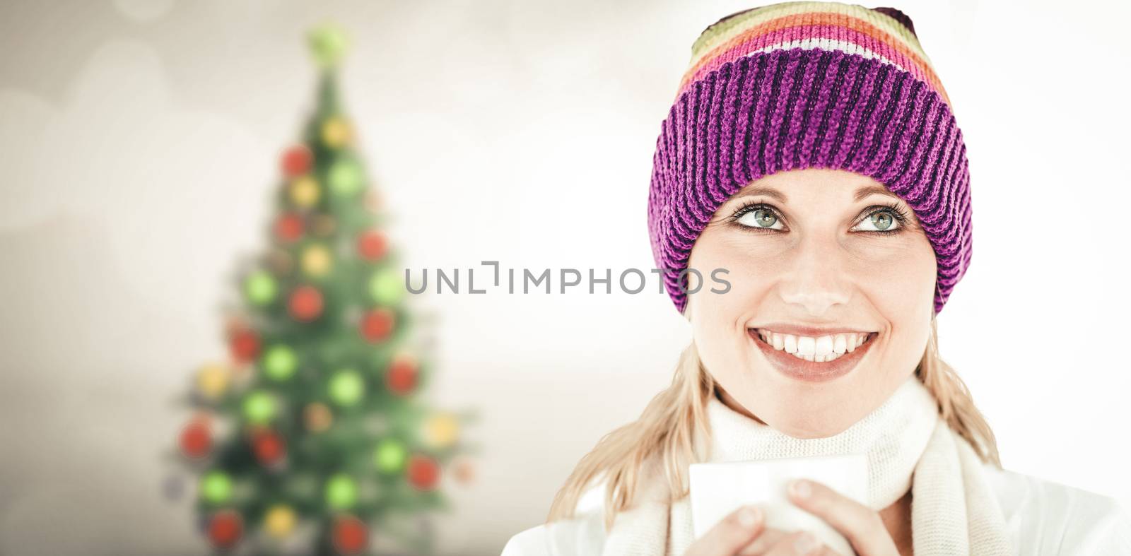 Composite image of smiling woman with a colorful hat and a cup in her hands by Wavebreakmedia