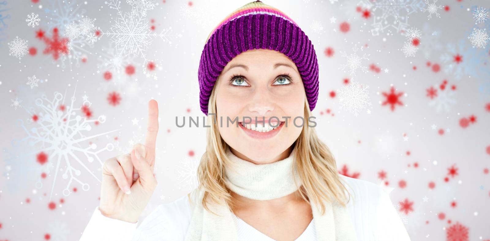 Bright woman with a colorful hat pointing upwards against snowflake pattern