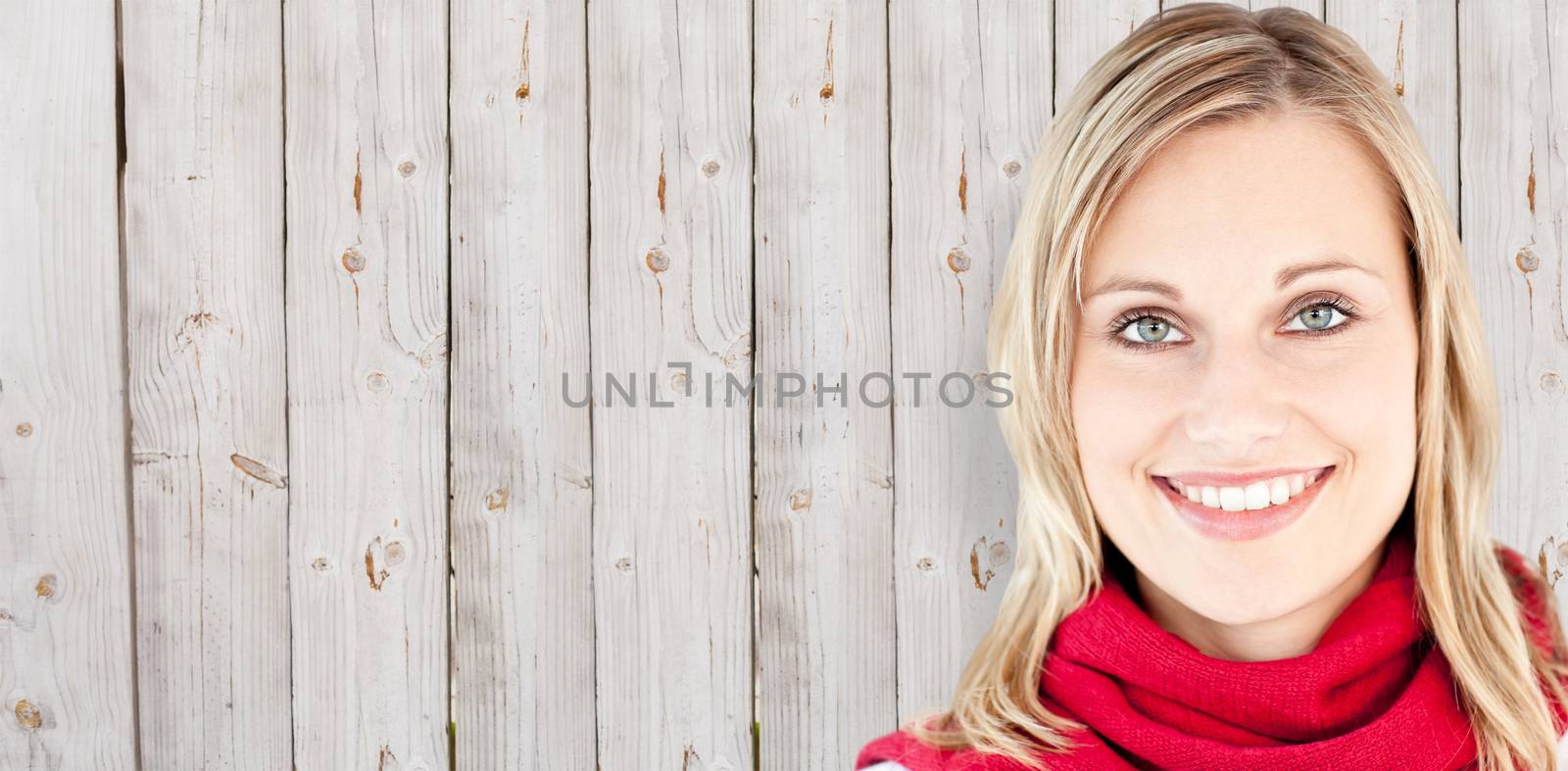 Portrait of a beautiful woman with a red scarf smiling at the camera against wooden background