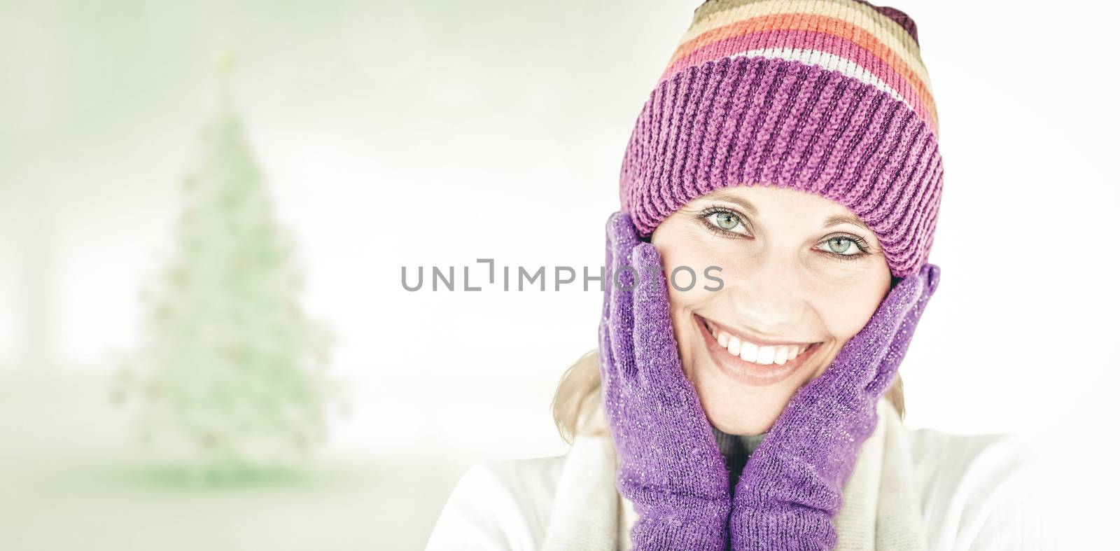 Radiant young woman with cap and gloves in the winter against blurry christmas tree in room