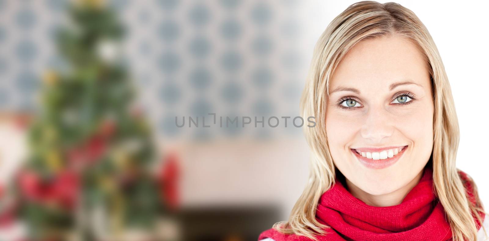 Portrait of a beautiful woman with a red scarf smiling at the camera against home at christmas time