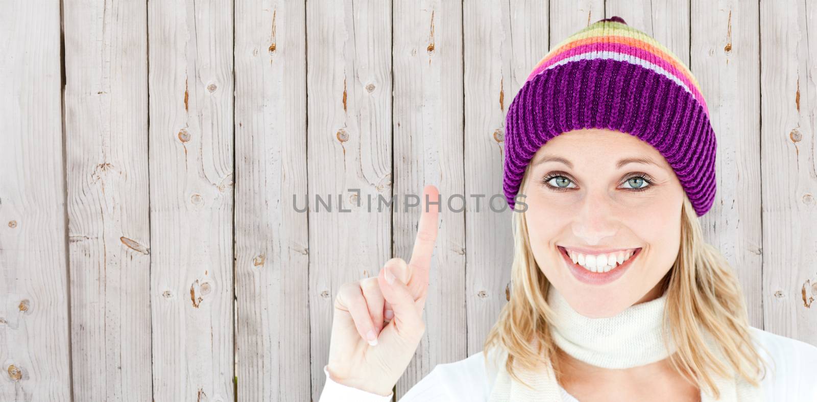 Positive woman showing up smiling at the camera against white background against wooden background