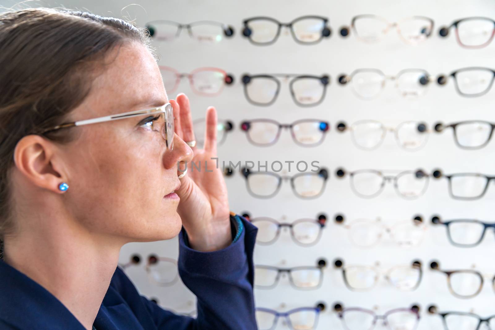 the glasses are selected and tested by a woman in an optics store. copy space by Edophoto