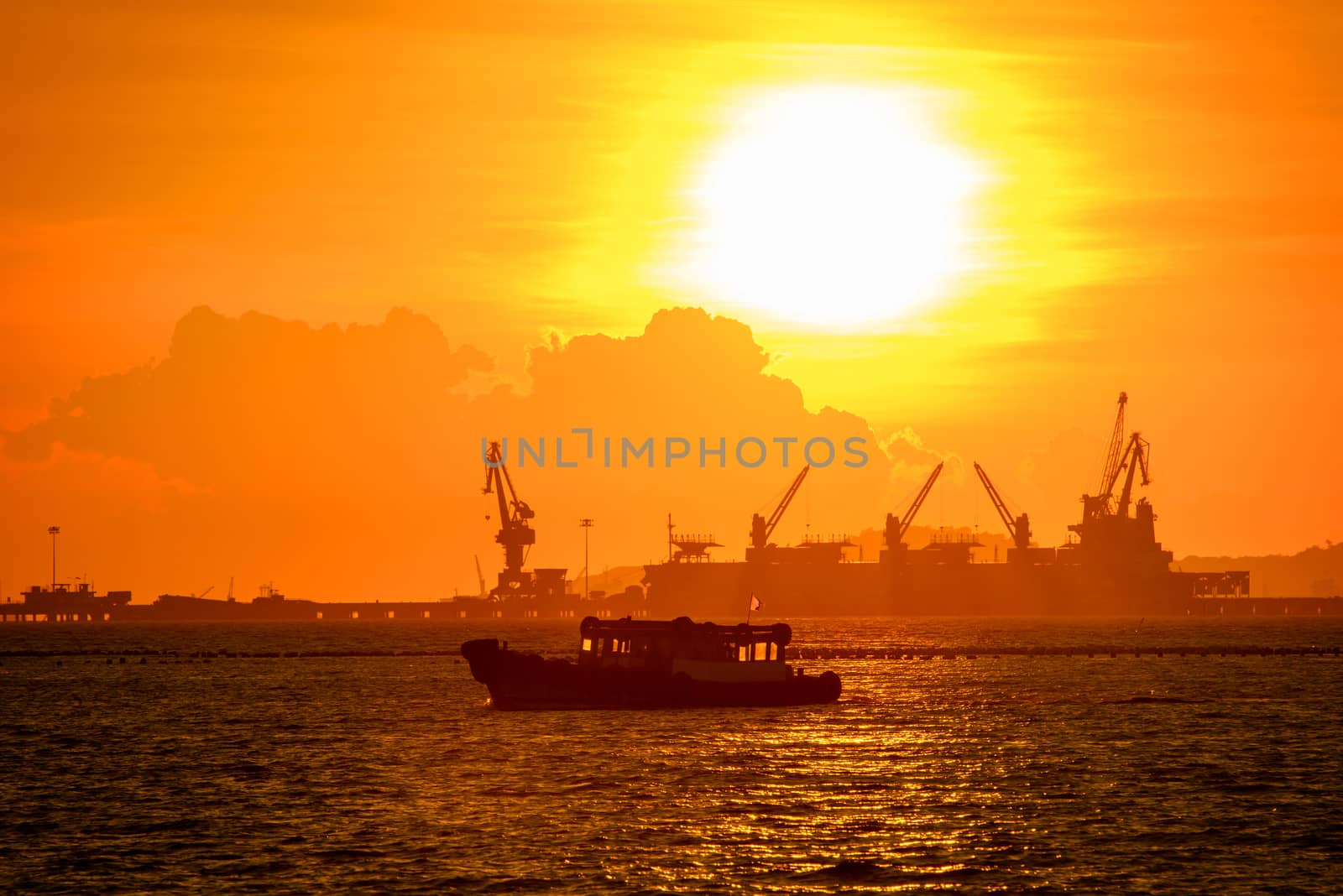 commercial dock with ship and cranes in sunset