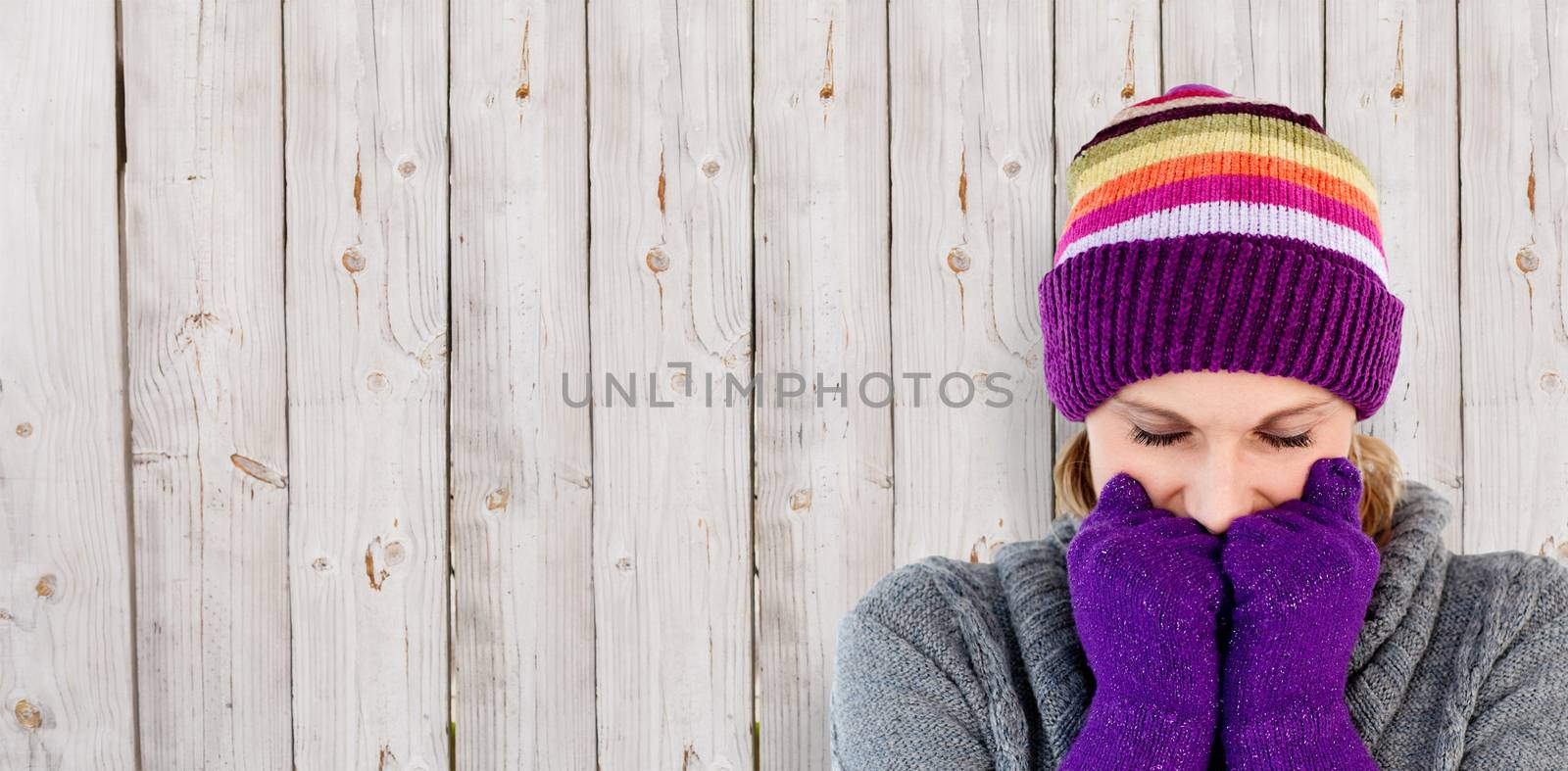 Freeze woman with gloves and a hat against wooden background