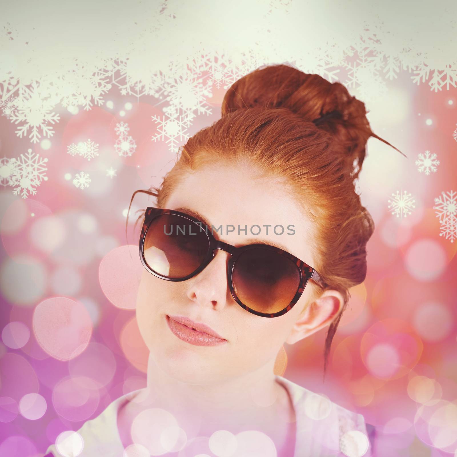 Hipster redhead wearing large sunglasses against snowflake pattern