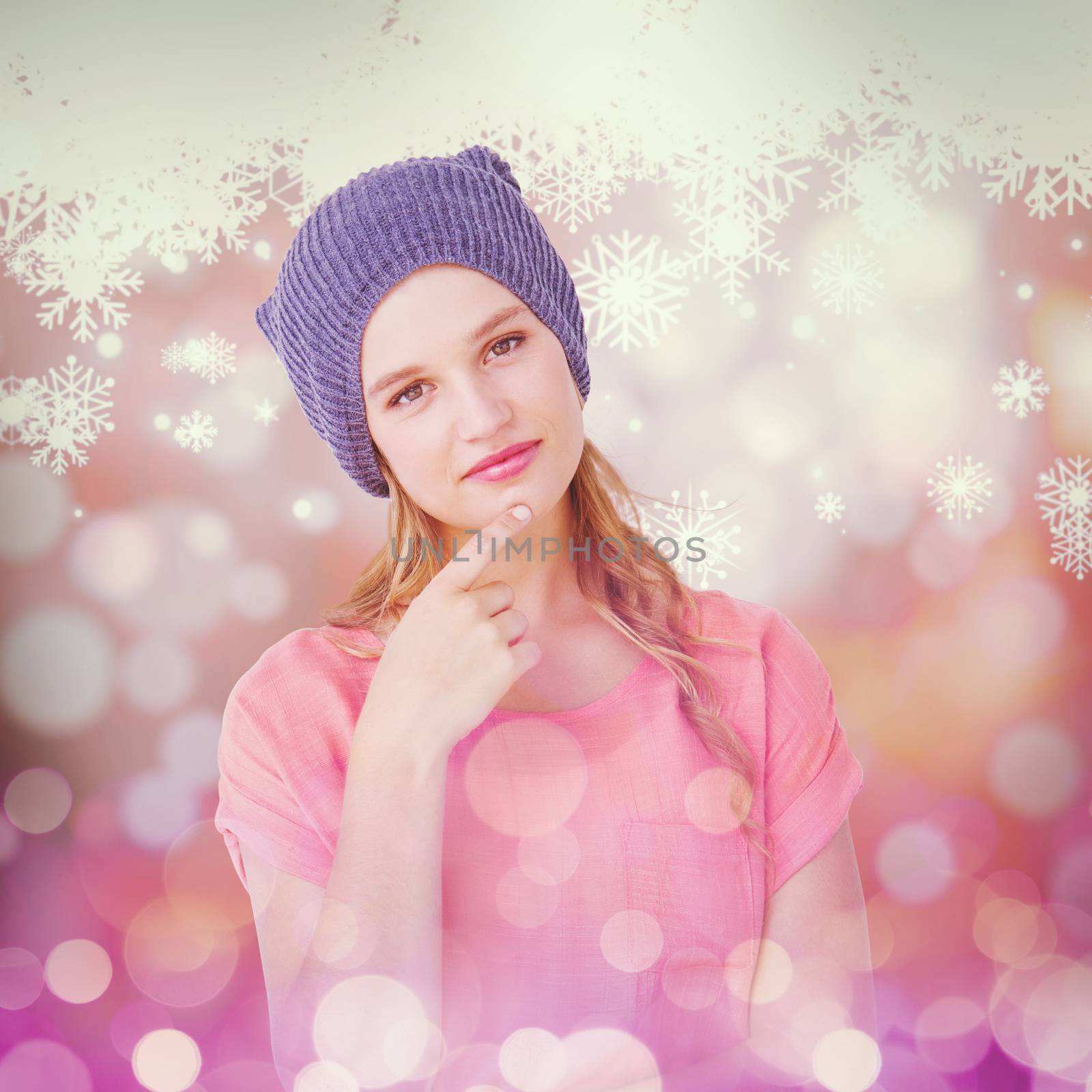 Hipster woman with hat looking at camera against snowflake pattern