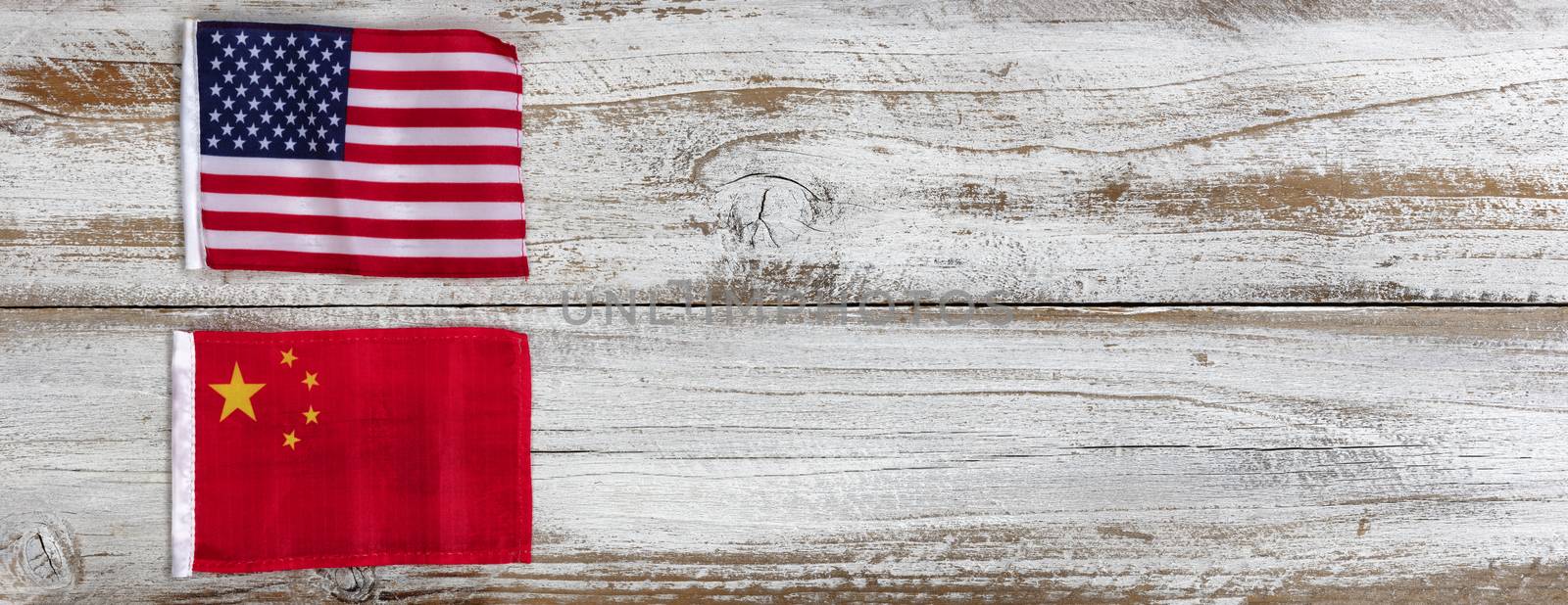 National flags representing China and the United States of America on white rustic wooden background. Trade war concept