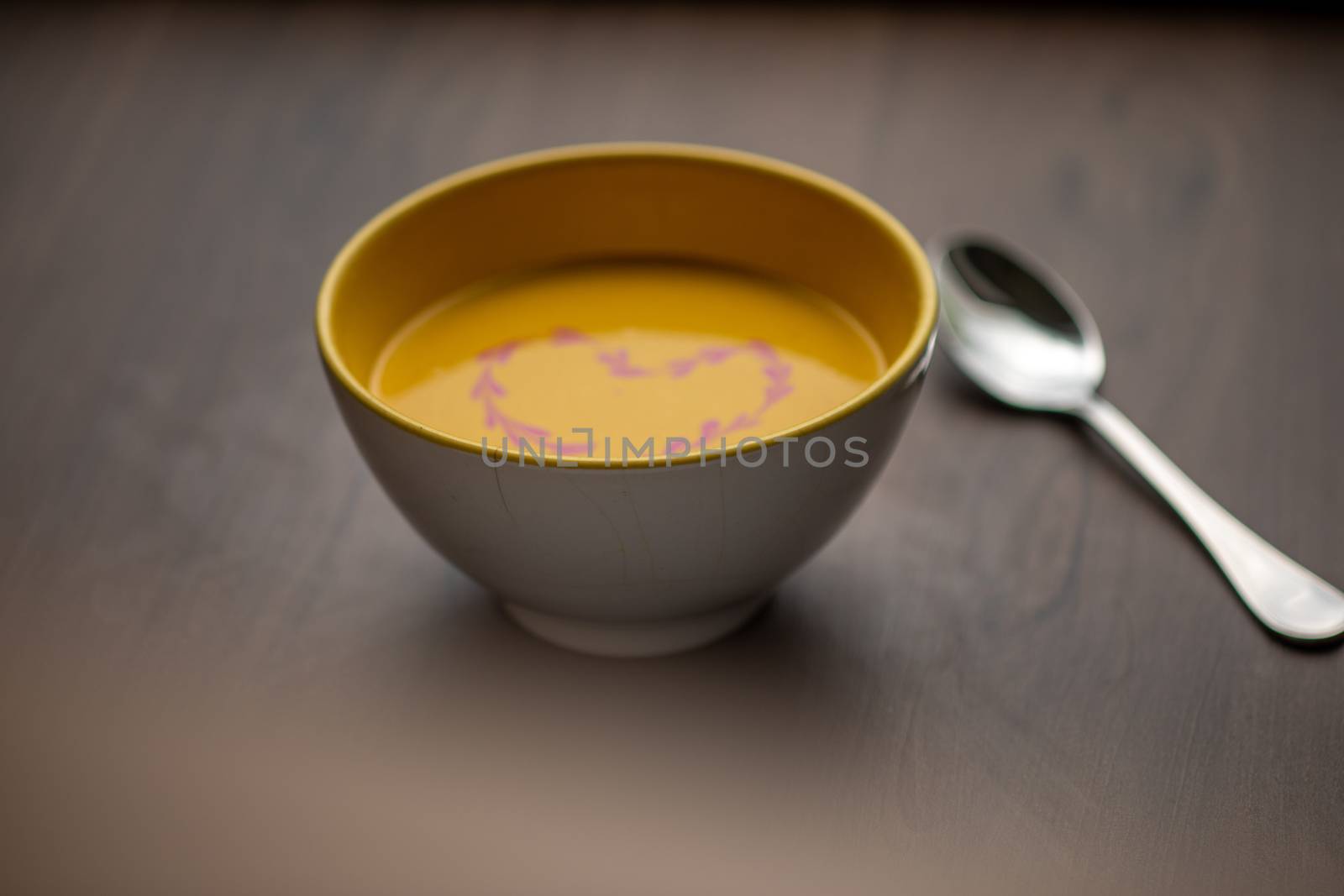 Vegetarian autumn - Pumpkin cream soup with hearth decoration on wooden table