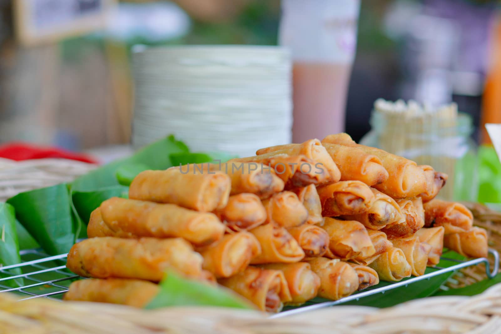 Delicious group of crispy spring roll on banana leave sell in local market of Thailand. Deep fries chinese snack.