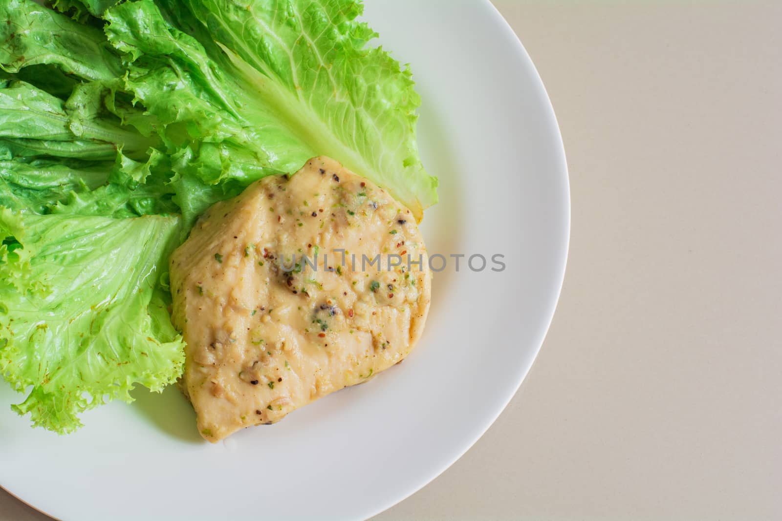 Chicken breast steak with spices serve with fresh green lettuce on white plate. High protein food. Healthy for loose weight.