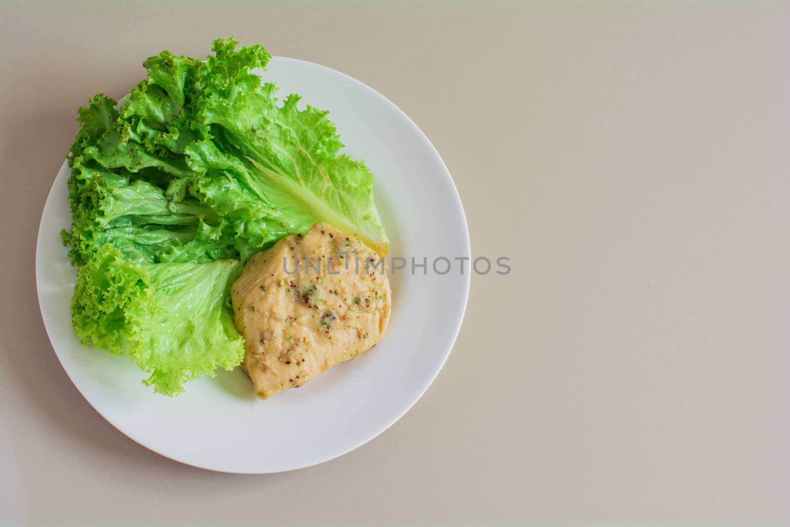 Chicken breast steak with spices serve with fresh green lettuce on white plate. High protein food. Healthy for loose weight.