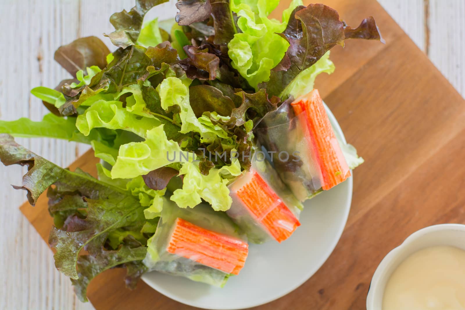 Crab stick in salad roll on white dish. Healthy food concept.