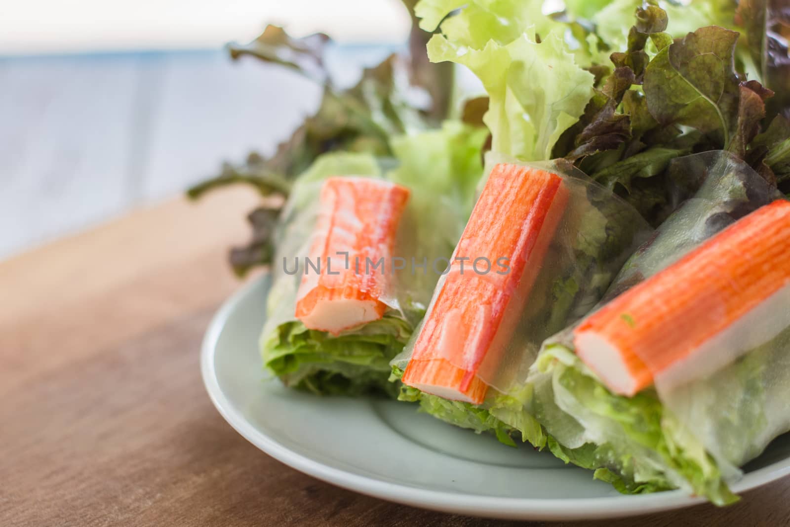 Crab stick in salad roll on white dish. Healthy food concept.