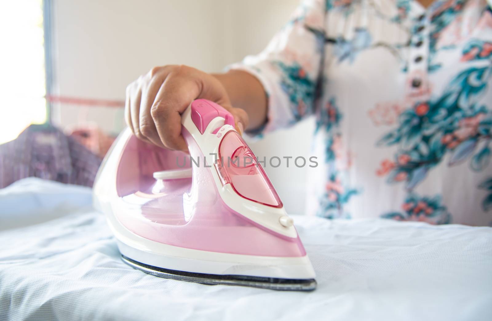 Close up of woman ironing clothes on ironing board