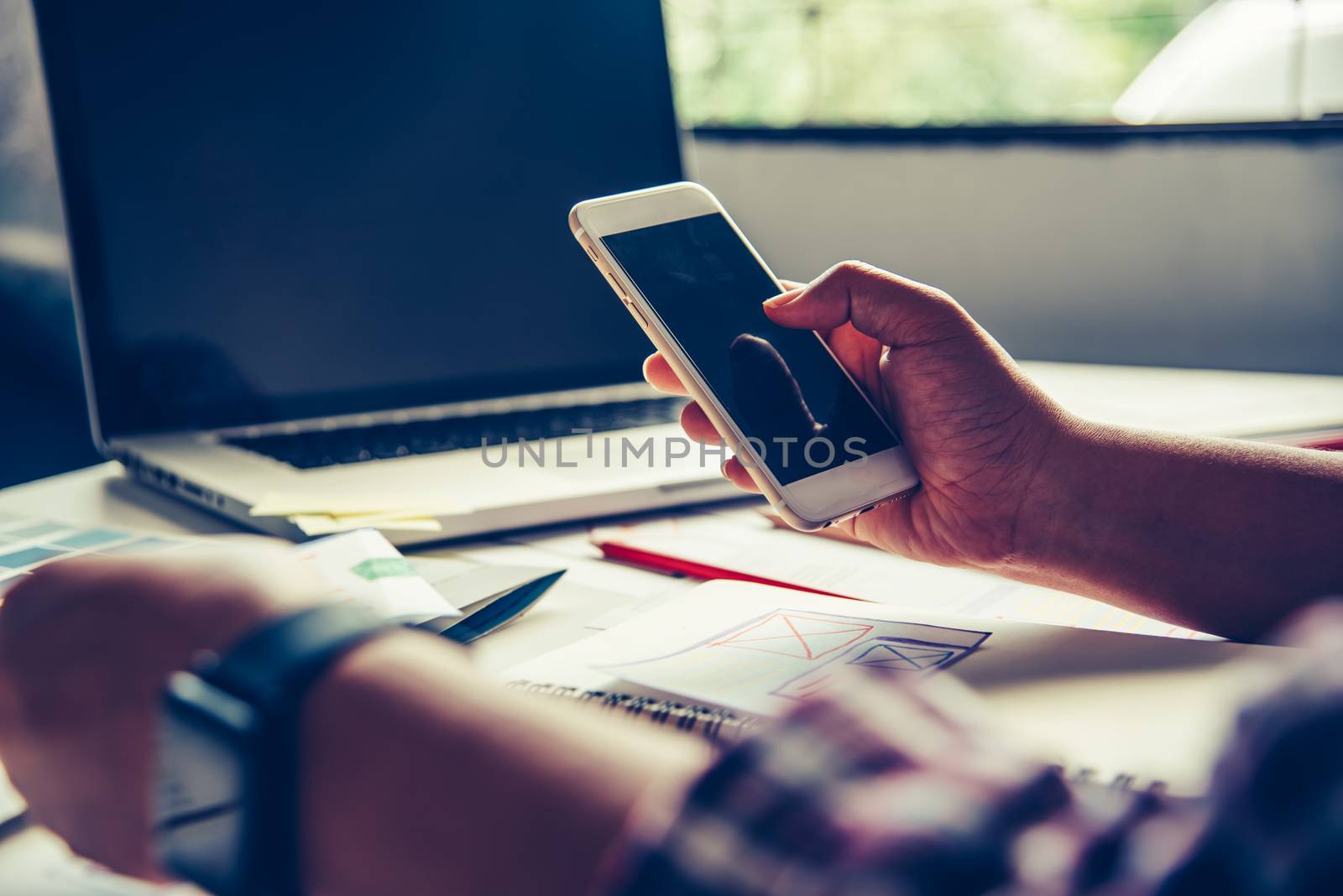 bussinessman are using their mobile to work with a laptop