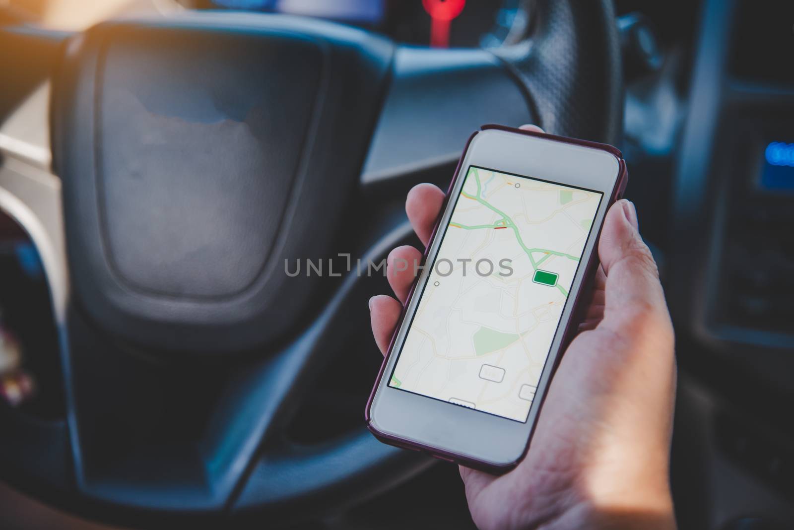  driver sitting in the car and holding  mobile smart phone with map gps navigation application