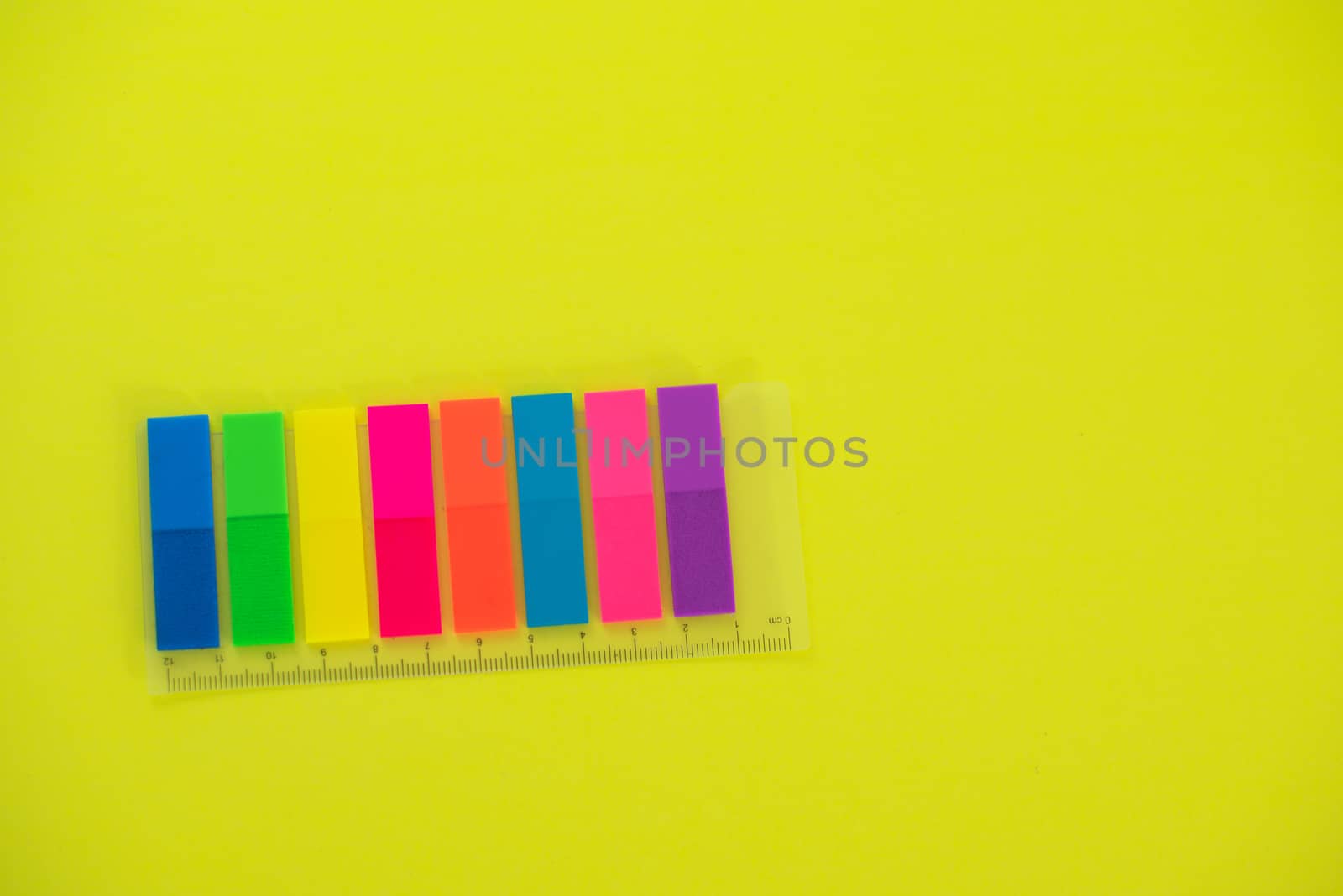 Assortment of colorful stickies against yellow background