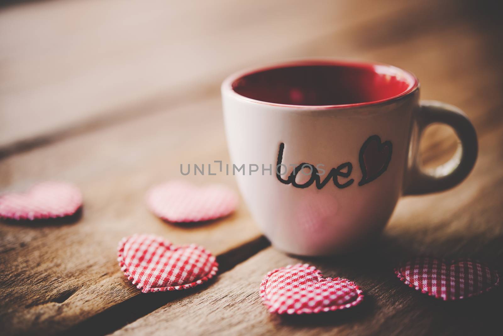 Glass with the words "Love" placed on the wooden floor