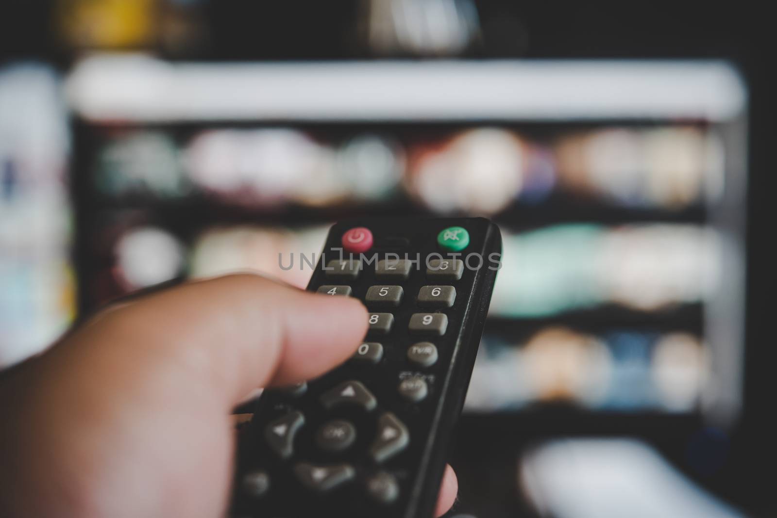 Watching  television, with a tv remote control in the hand 