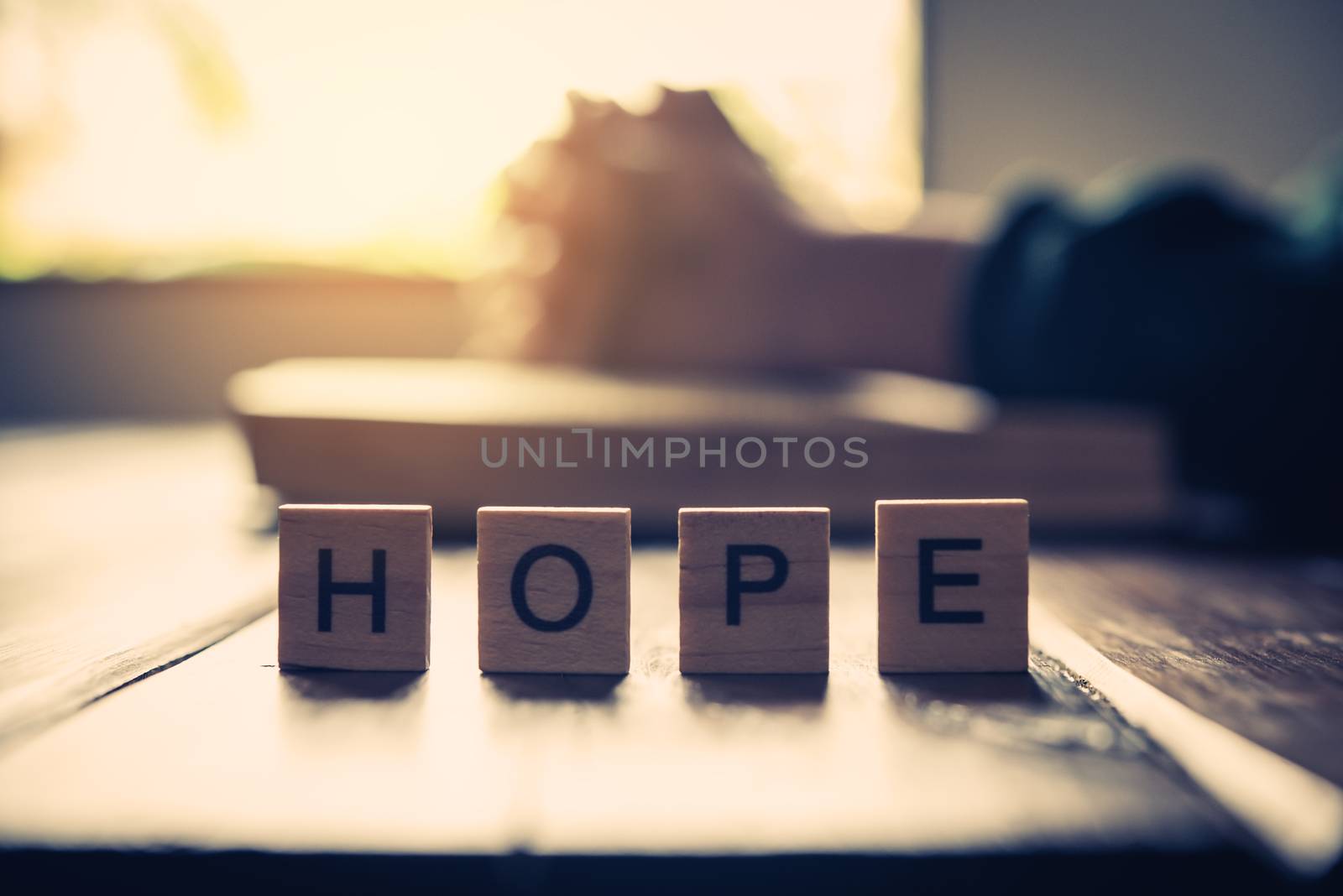 The letter "HOPE" is placed on the table with Christians praying and praying to God in the back.