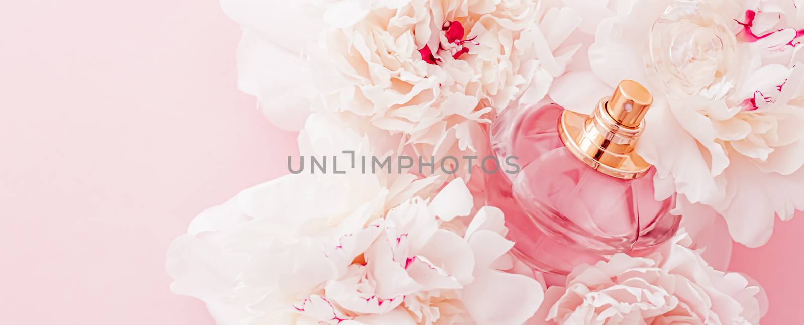 Luxe fragrance bottle as girly perfume product on background of peony flowers, parfum ad and beauty branding design