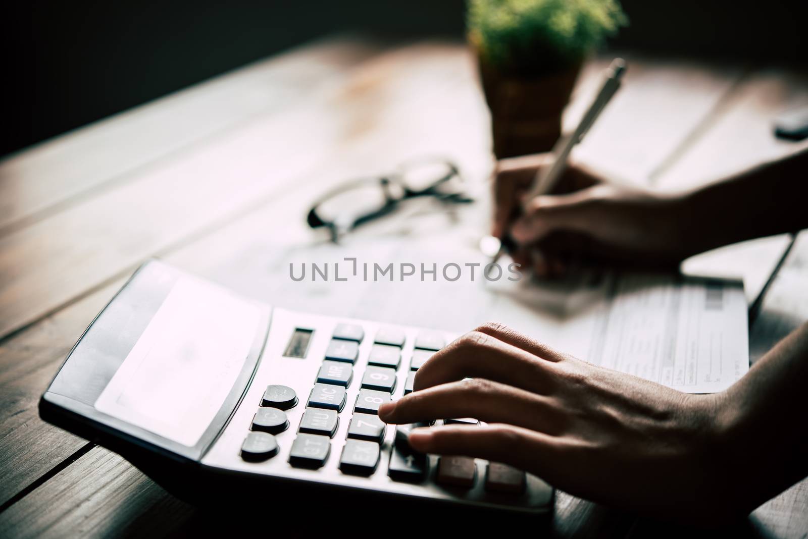 Businessmen are using a calculator to calculate the income of the business.