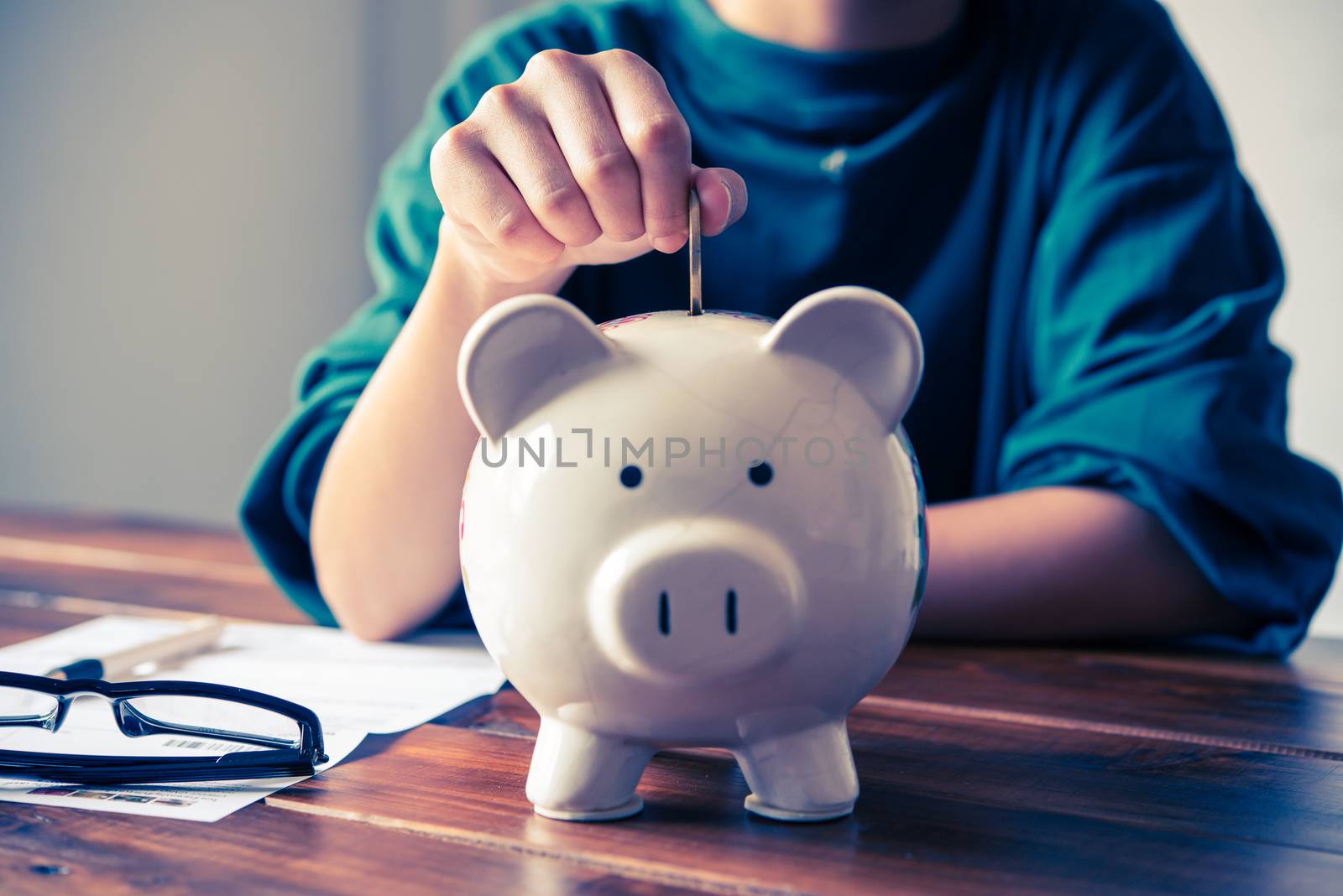 Hands are money  into a piggy bank - concept of saving.