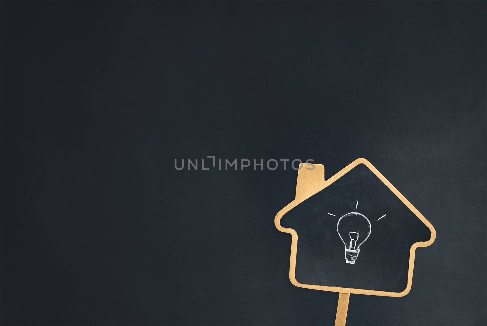 a house sign chalkboard with a light bulb symbol showing idea of knowledge gained from homeschooling education. studying class or learning from a tutoring course. blank blackboard background for text.