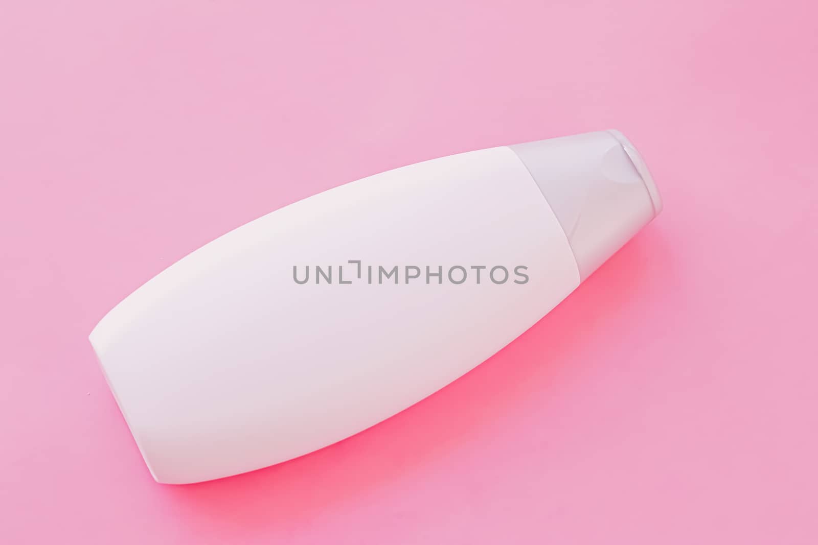 Blank label shampoo bottle or shower gel on pink background, beauty product and body care cosmetics, flatlay