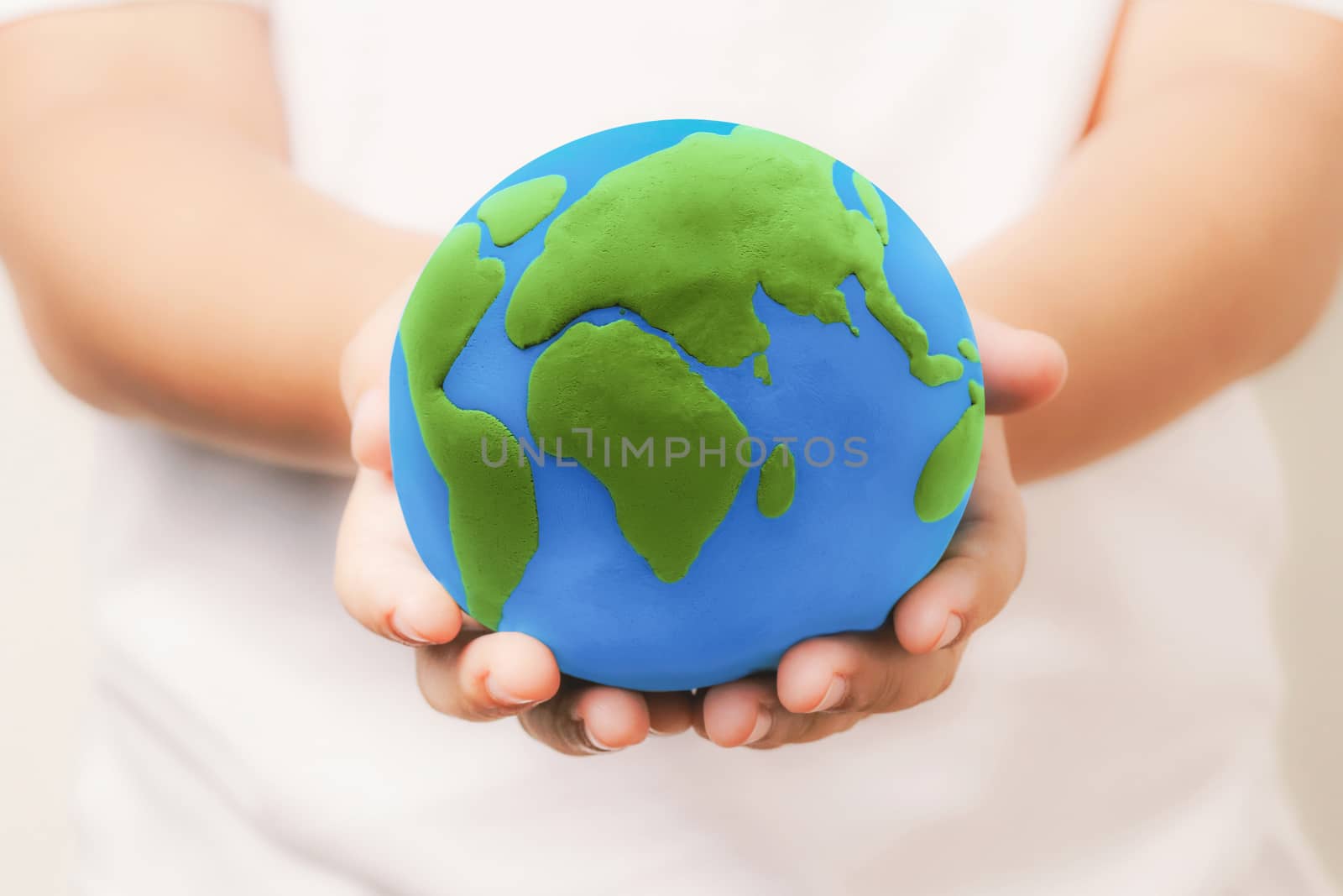 kid holding the clay globe in hand