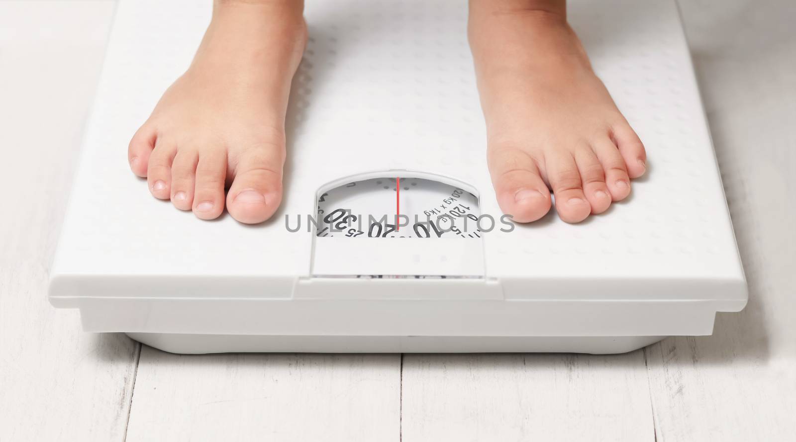 kids feet on white weight scale by winnond