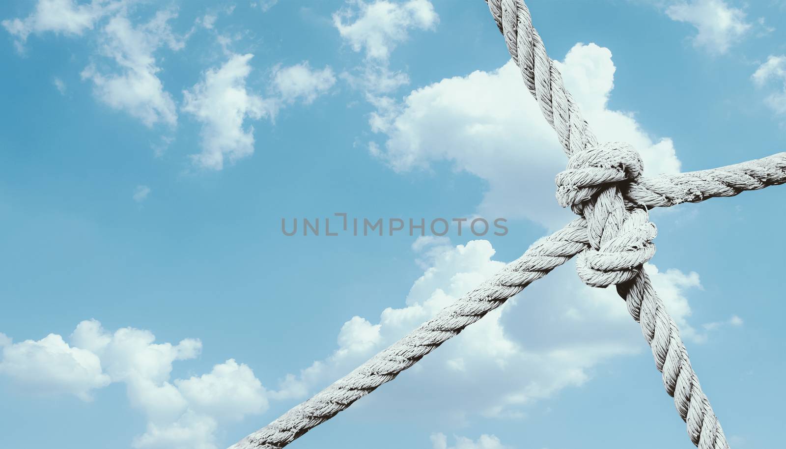 rope knot of net against blue sky background. unity and collaboration concept