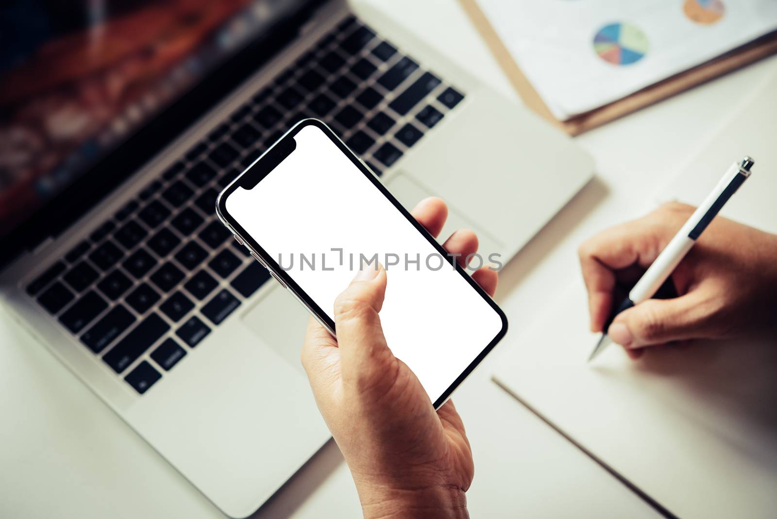 Mockup image of hand holding mobile phone blank white screen in office business concept