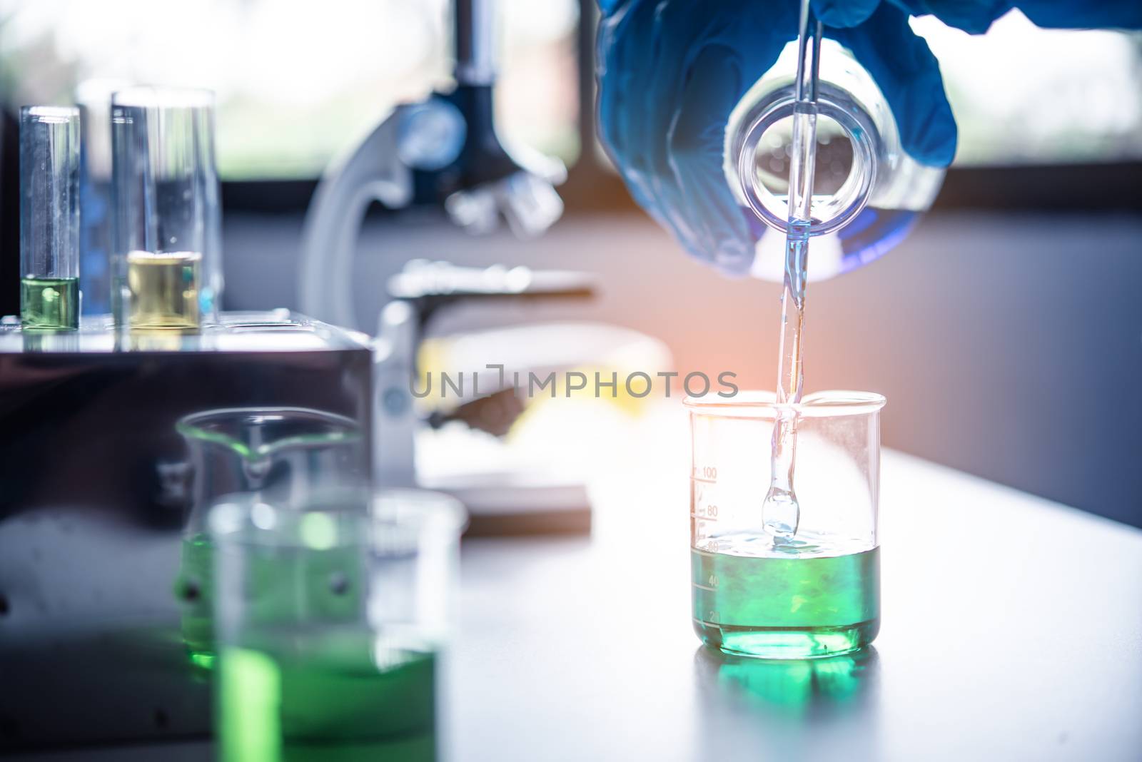  Equipment and science experiments oil pouring scientist with test tube yellow making research in laboratory.