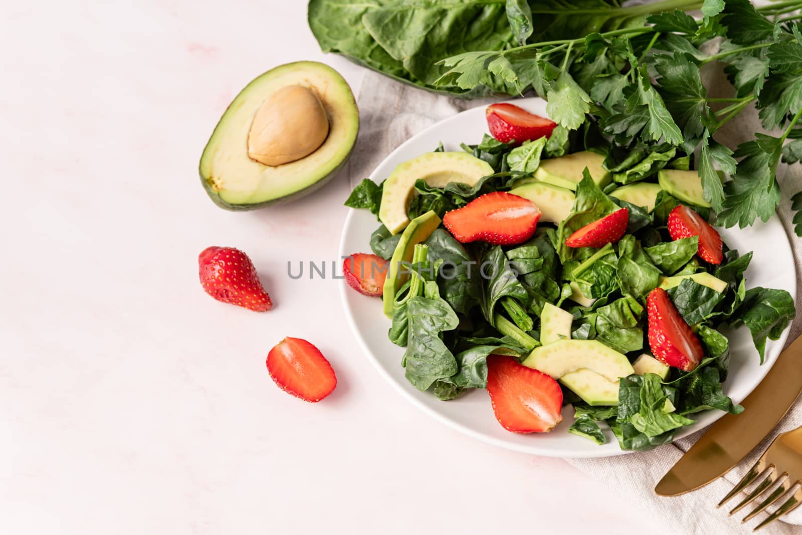 Ketogenic diet. Vegetarian food. Healthy food concept. Avocado, spinach and strawberry salad high angle view on white background with copy space