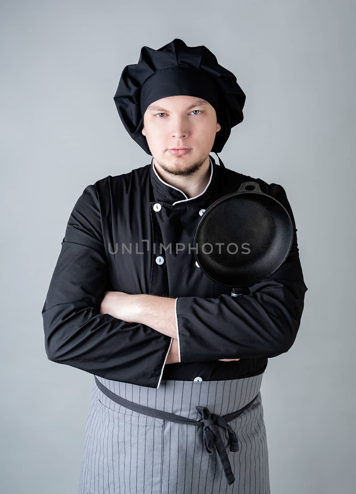 Male chef holding a saucepan isolated on gray background by Desperada