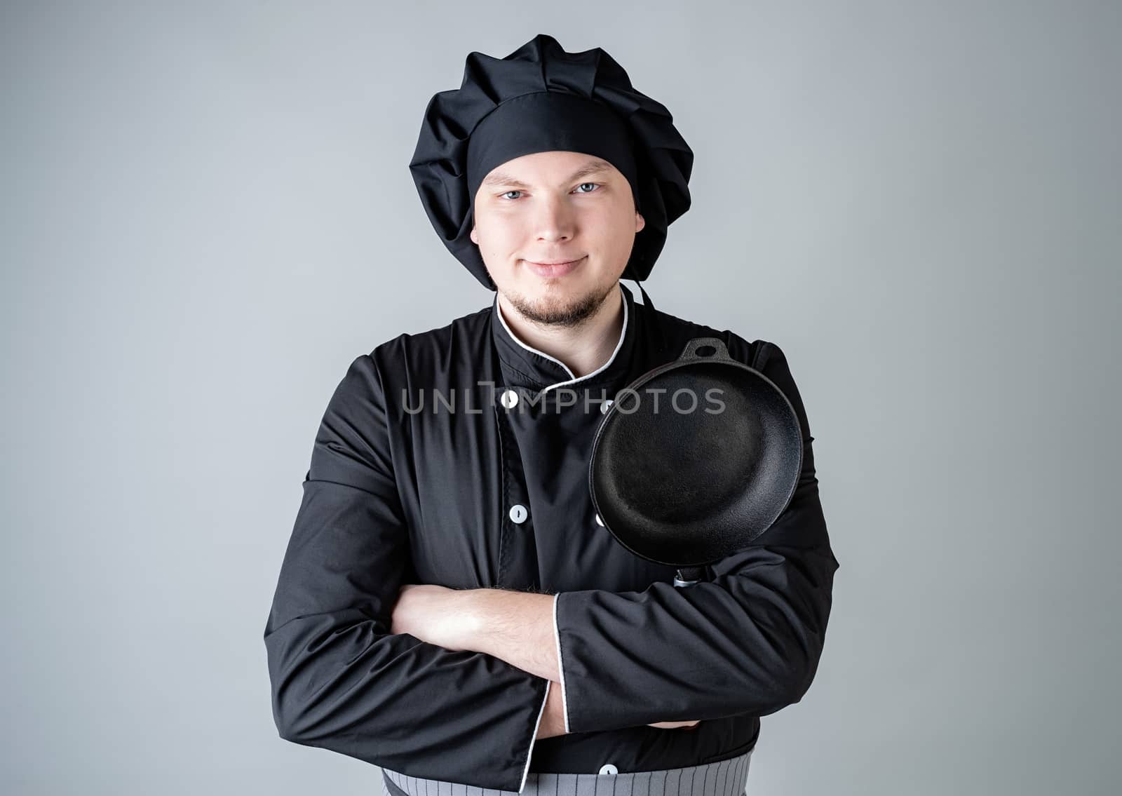 Male chef holding a saucepan isolated on gray background by Desperada