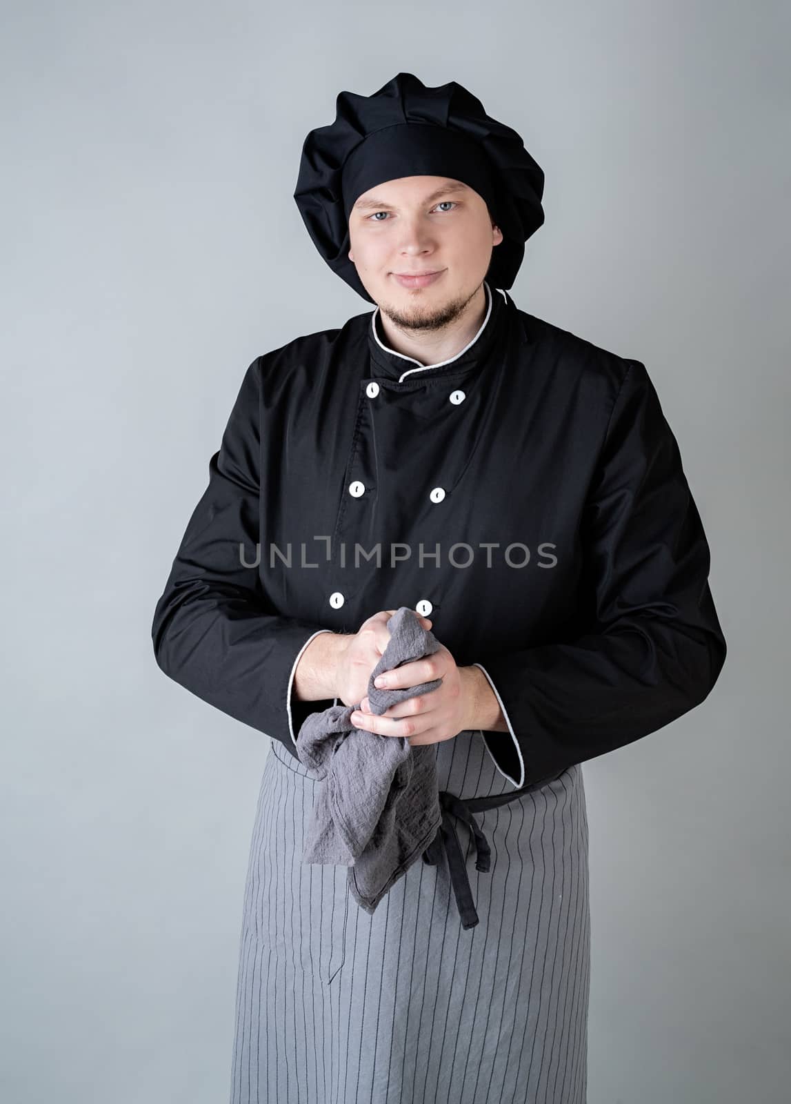 Male chef wipping his hands isolated on gray background by Desperada