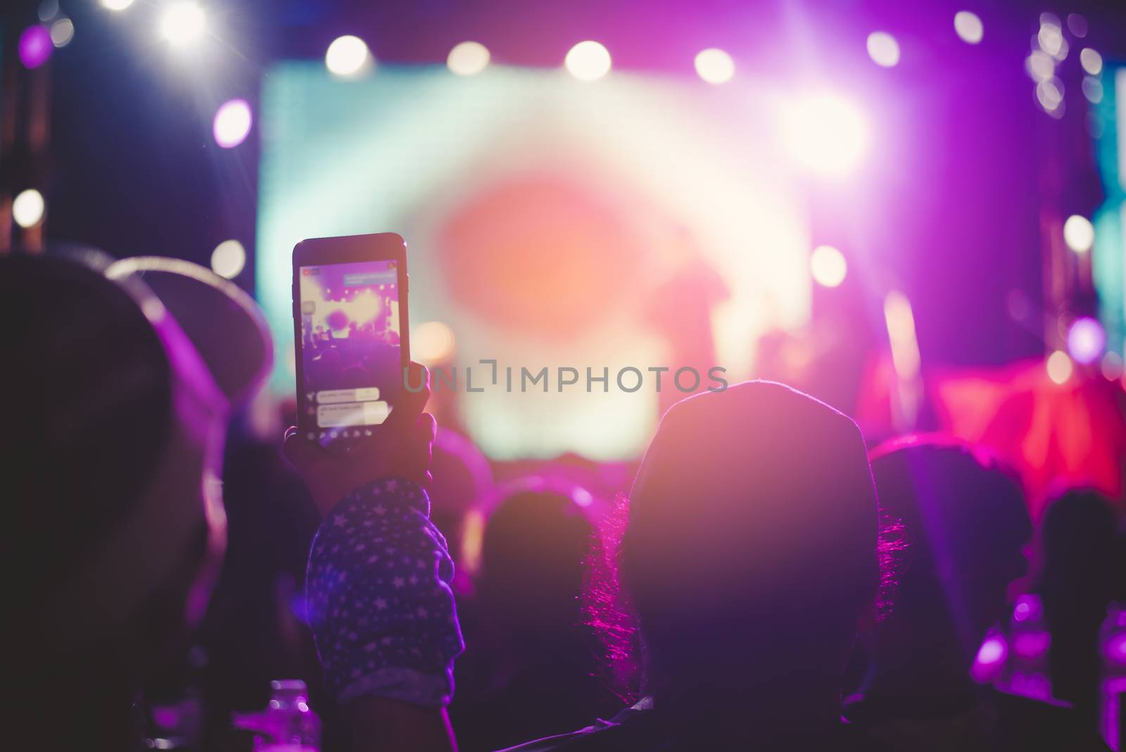 Fans are having fun, both taking pictures with the camera and mobile phone. Concert performer